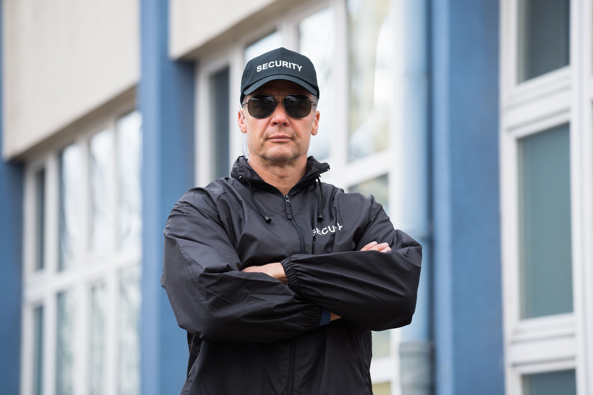 Security Guard Standing Arms Crossed Outside Building